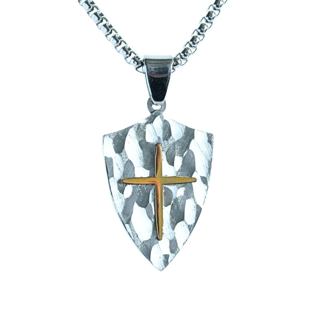 Stainless steel shield pendant with hammered texture and raised gold-tone cross on chain.