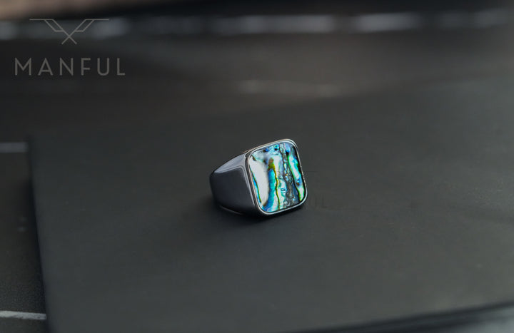 Abalone Shell Signet Ring, resting on a black card with a softly blurred dark background