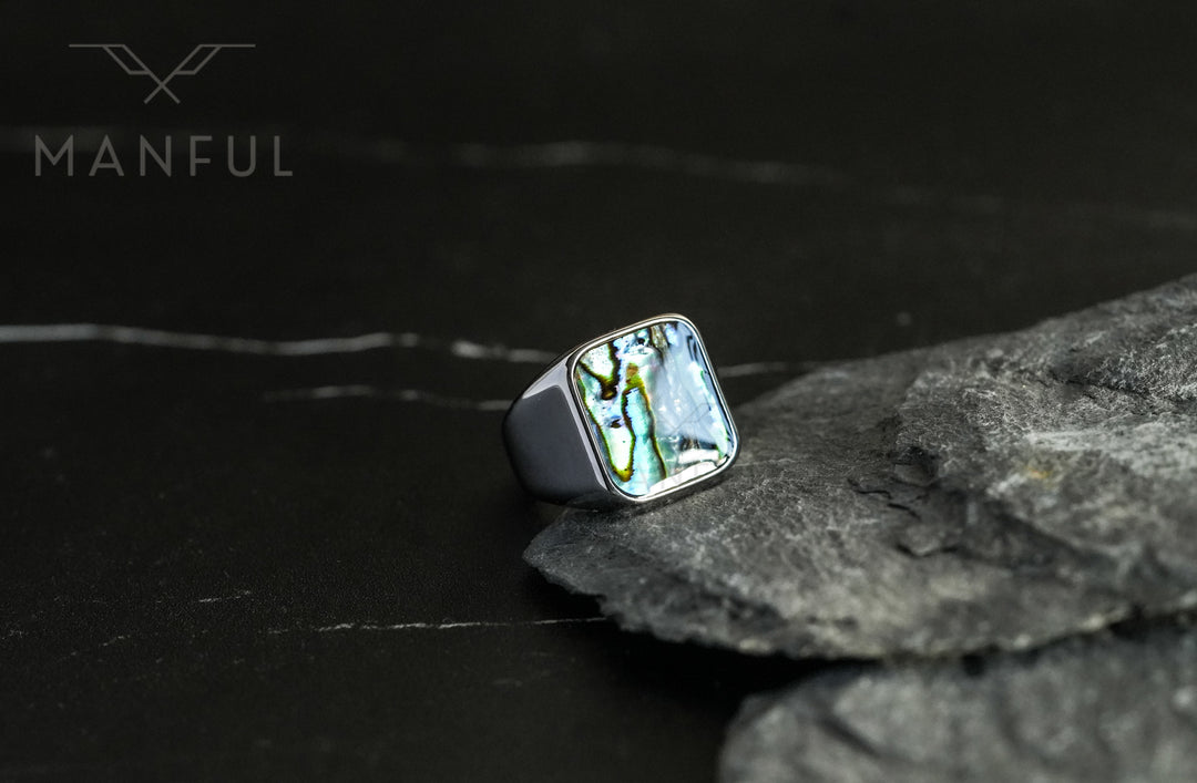 Abalone Shell Signet Ring, propped against a piece of grey slate rock