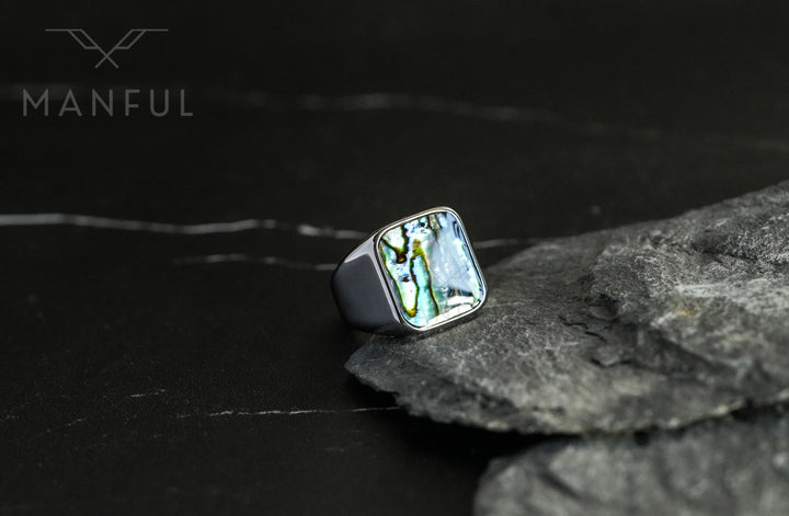 Abalone Shell Signet Ring, propped against a piece of grey slate rock