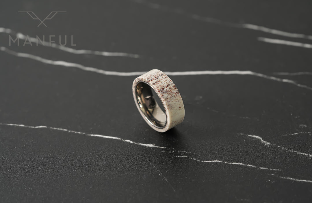 Antler & Titanium Band, standing at an angle on a dark marble surface