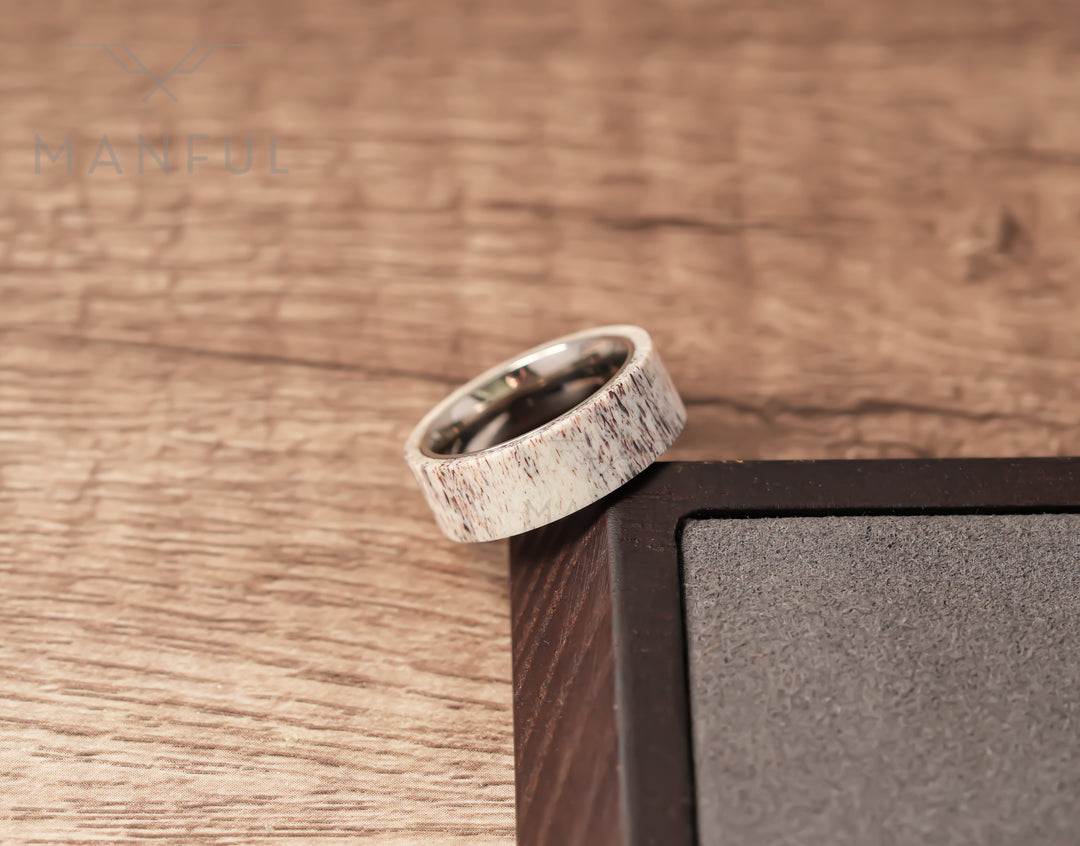 Antler & Titanium Band, propped against a dark block corner in a tighter crop on woodgrain