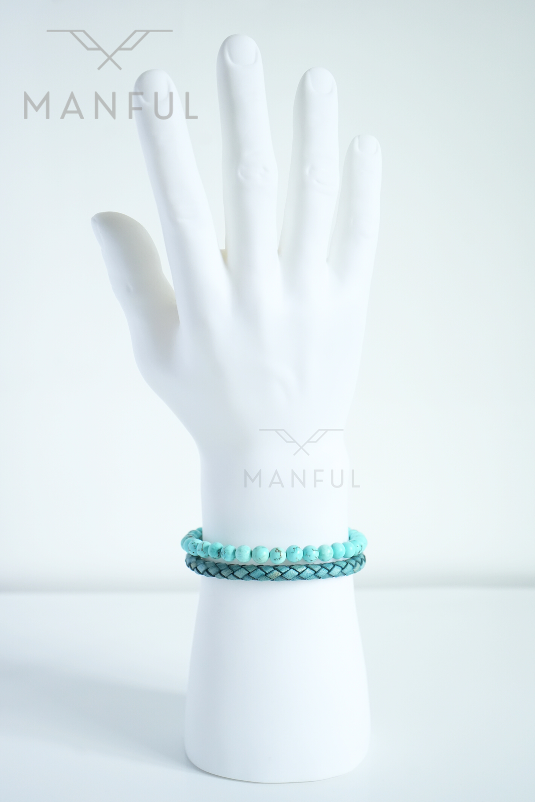 Aqua Bead And Leather Bracelet, stacked with a darker woven bracelet on a white mannequin wrist