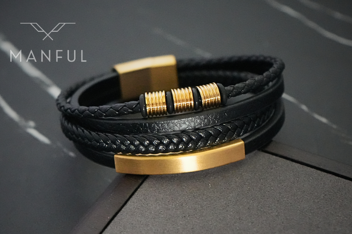 Black & Gold Leather Bracelet, close up on dark marble highlighting the gold ID plate and clasp