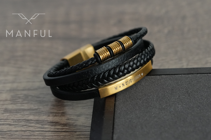 Black & Gold Leather Bracelet, coiled on wood showing the gold beads and engraved bar