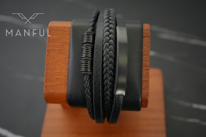 Black Leather Bracelet, close-up on a wood block prop against a dark marble backdrop