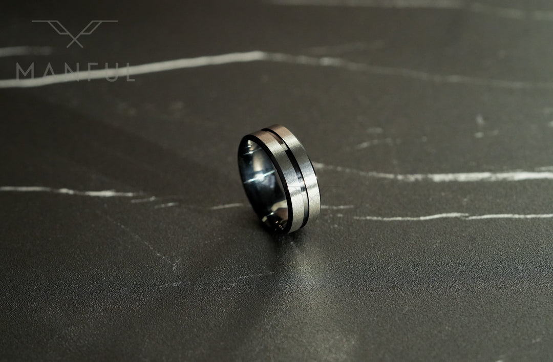 Black Onyx and Silver Band, tilted on a dark marble surface with the silver centre line facing forward