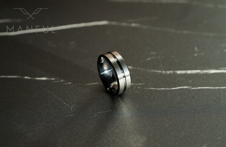 Black Onyx and Silver Band, tilted on a dark marble surface with the silver centre line facing forward