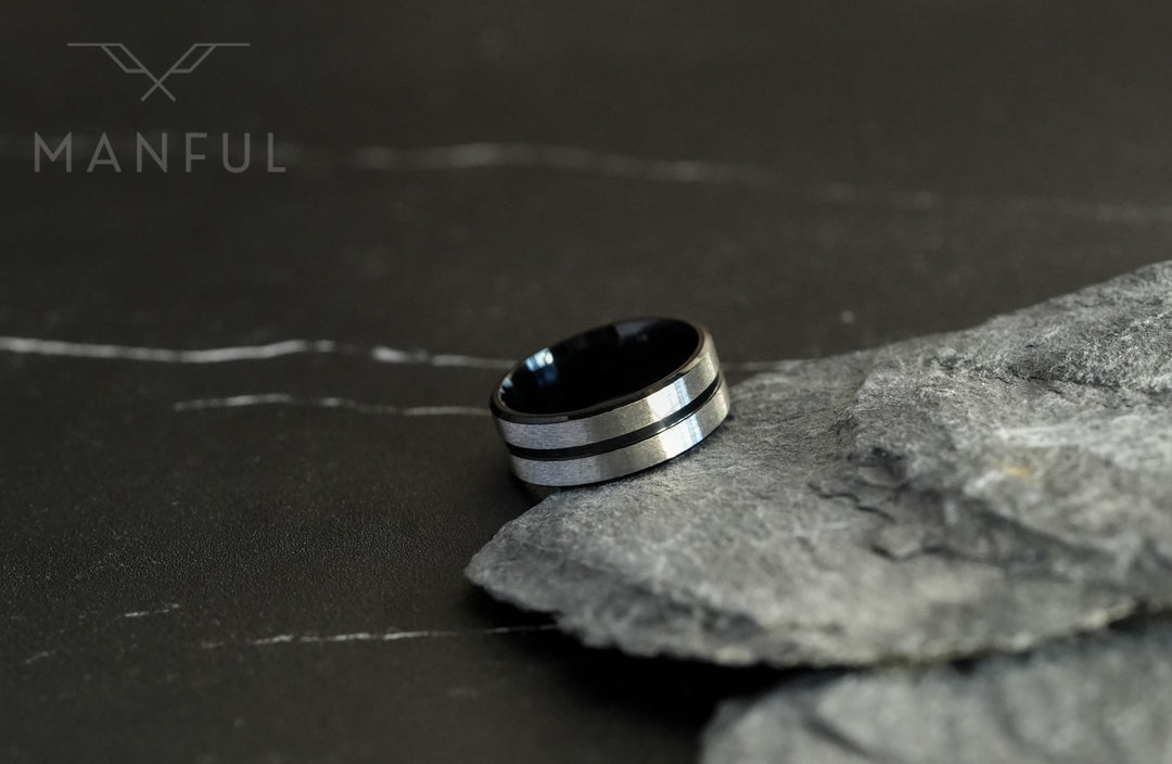 Black Onyx and Silver Band, tilted on a dark marble surface beside a slate stone prop