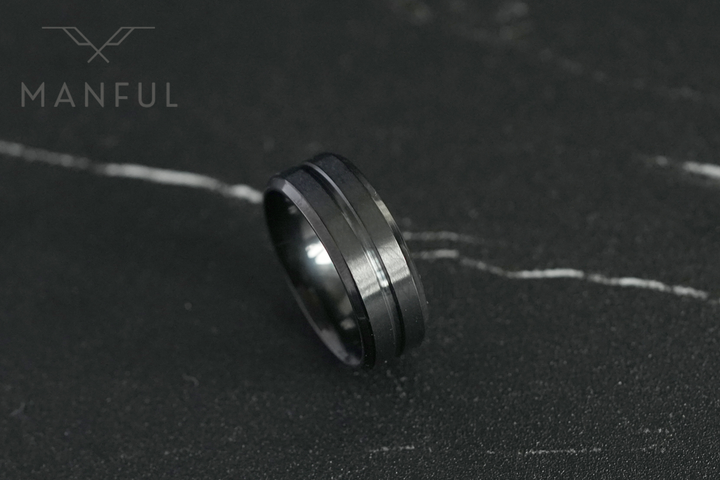 Black Onyx Band, lying flat on a dark veined marble surface with the Manful logo in the corner