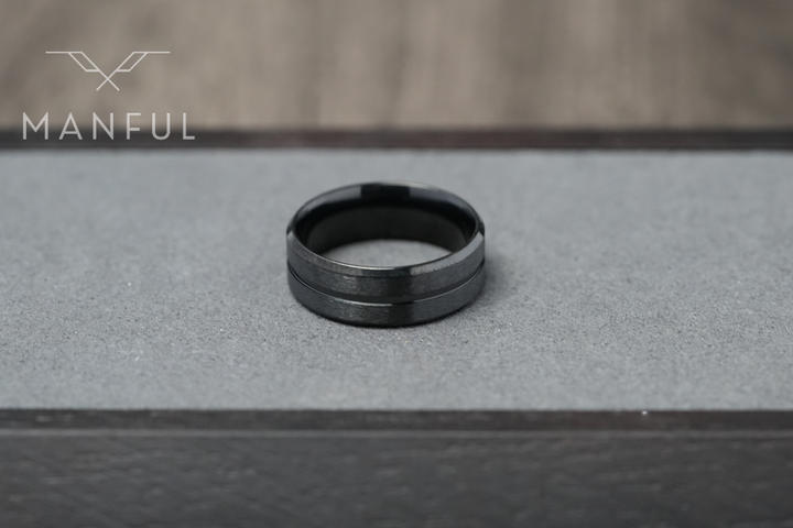 Black Onyx Band, set on a grey display platform framed by dark wood edges