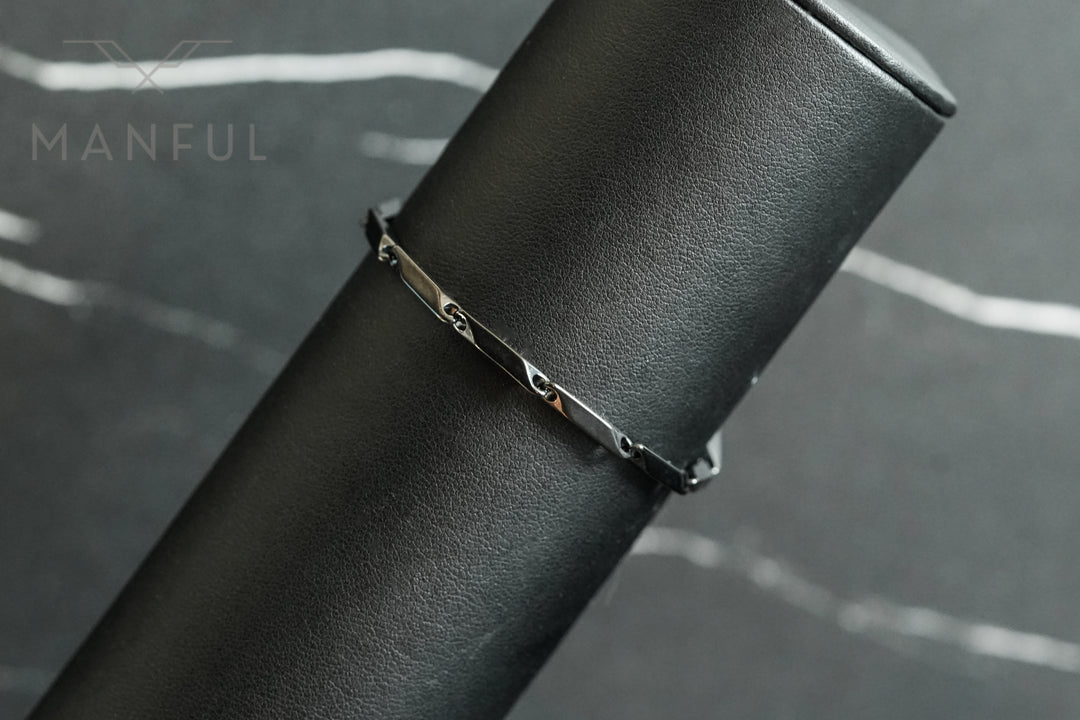 Block Chain Bracelet Black, draped over a black leather cylindrical prop