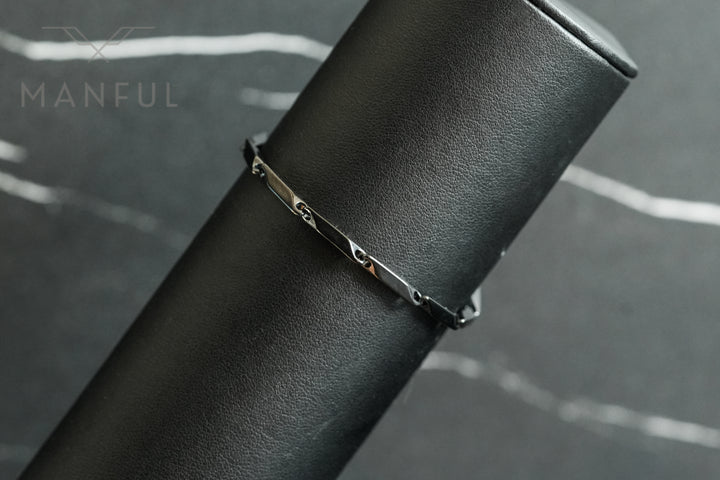 Block Chain Bracelet Black, draped over a black leather cylindrical prop