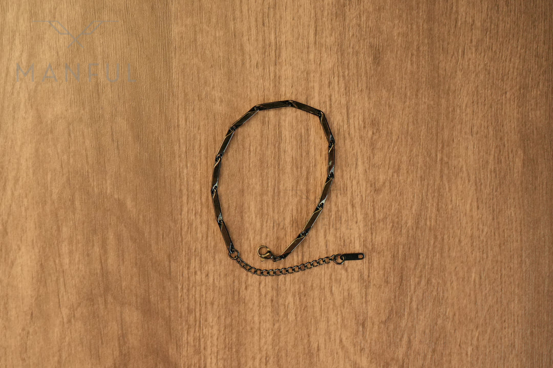 Block Chain Bracelet Black, flat lay in a circular loop on a wood surface