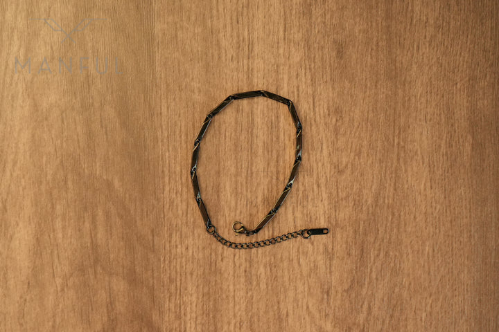 Block Chain Bracelet Black, flat lay in a circular loop on a wood surface