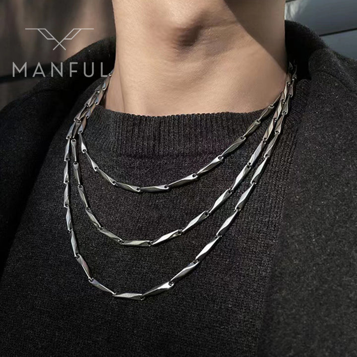 Block Chain Necklace, worn layered on a man's neck over a dark sweater