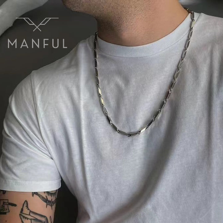 Block Chain Necklace, worn on a man's neck over a white t-shirt