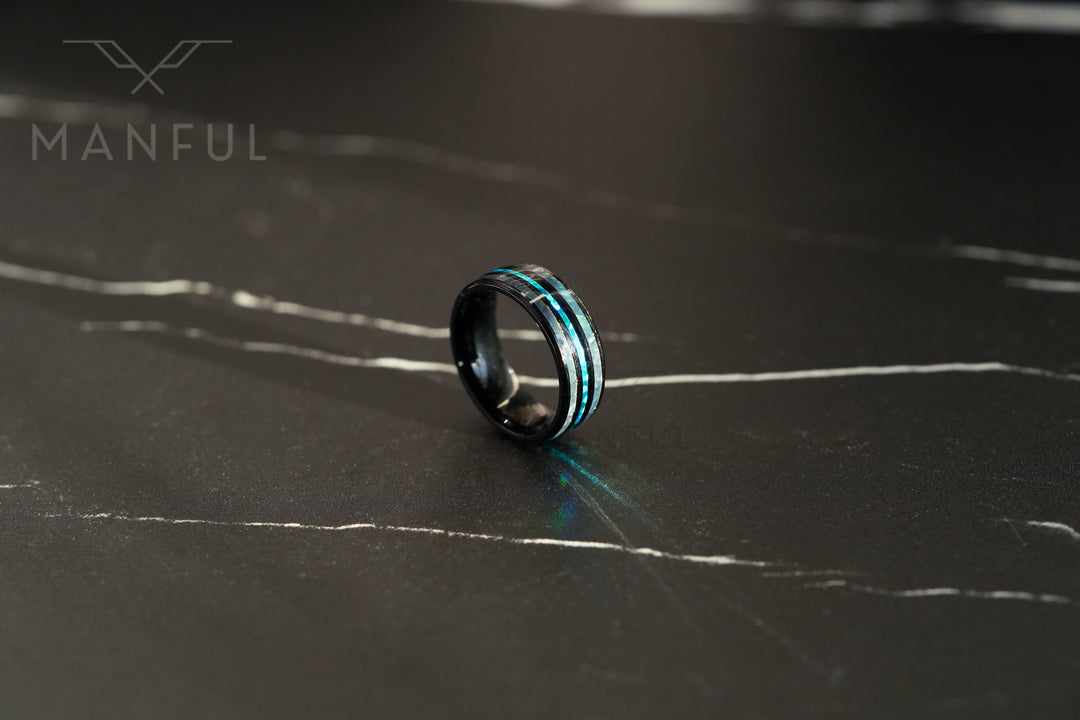 Blue Crystal Ring, angled on a dark marble surface showing the thin teal inlay stripe