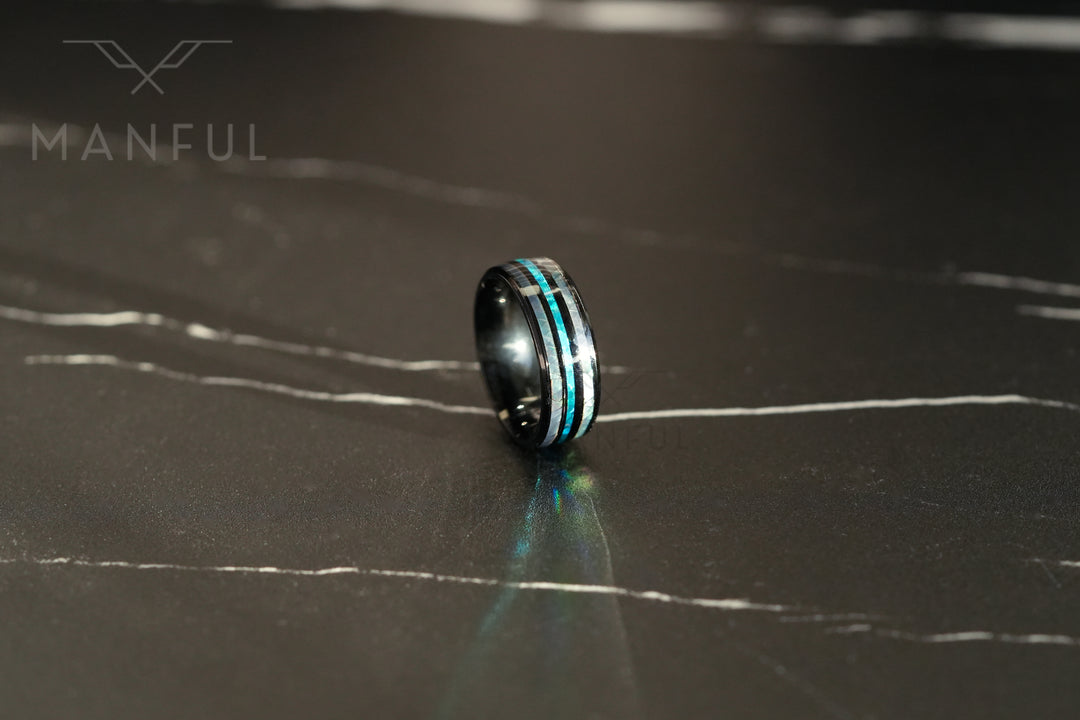 Blue Crystal Ring, standing upright on dark marble with light reflecting off the band