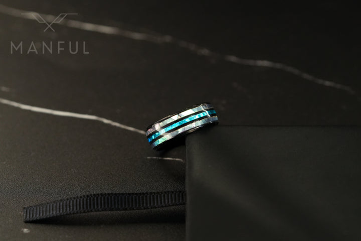 Blue Crystal Ring, tilted against the corner of a black tray on a dark marble surface