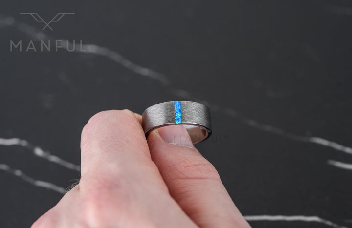Azure Opal Line Tungsten Band, worn on a man's finger in a close-up hand shot
