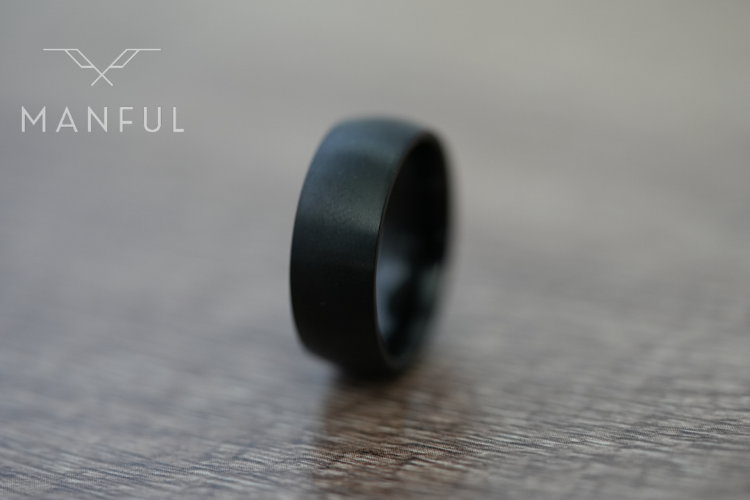 Brushed Titanium Band Black, standing on a wood-grain surface, leaning to the right