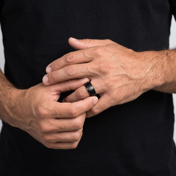 Brushed Titanium Band (Black) on a man's finger as his other hand turns it