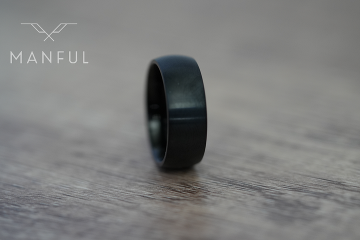 Brushed Titanium Band Black, standing on a wood-grain surface, leaning to the left