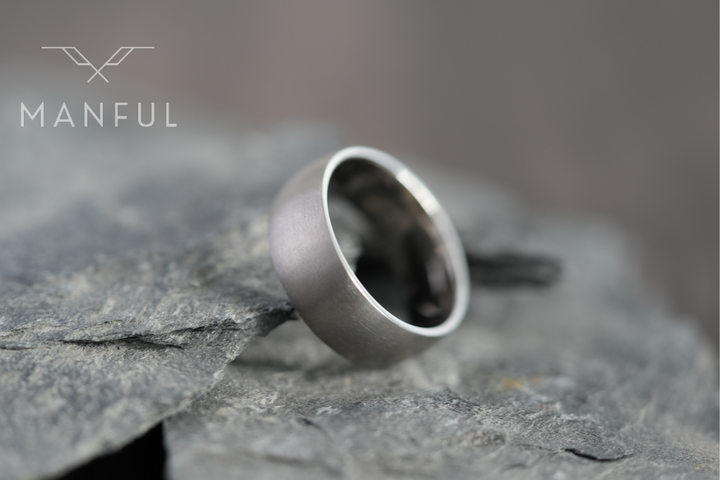 Brushed Titanium Band Silver, leaning against a slate stone slab at an angle