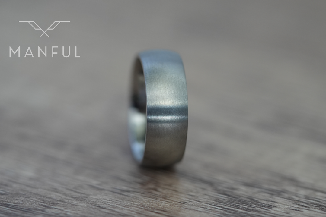 Brushed Titanium Band Silver, standing front-on on a wood surface with a blurred background