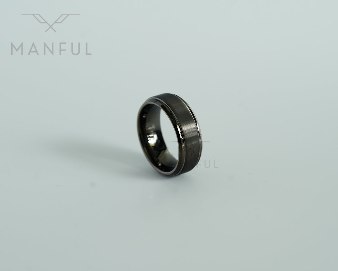 Brushed Tungsten Band Gunmetal, standing at an angle on a plain grey background with its reflection below