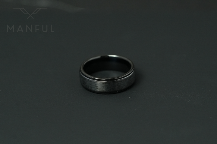 Brushed Tungsten Band Black, standing upright on a plain dark grey background