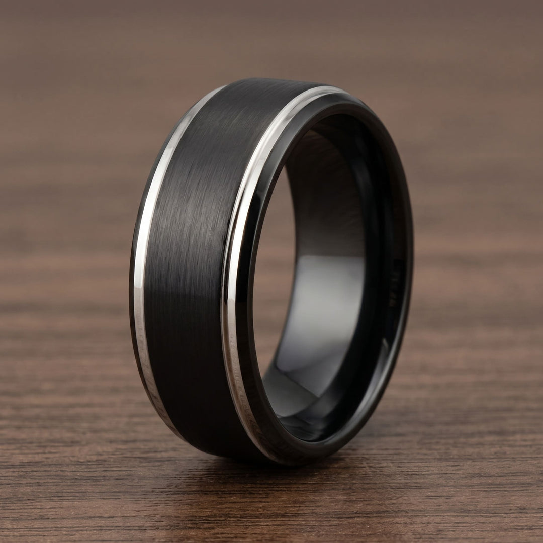 Brushed Tungsten Black & Silver Band standing on a walnut table