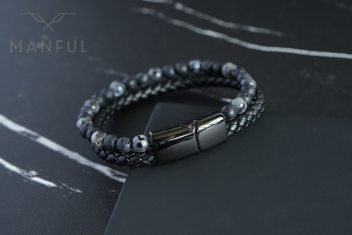Charcoal Bead And Leather Bracelet, coiled on a dark marble surface