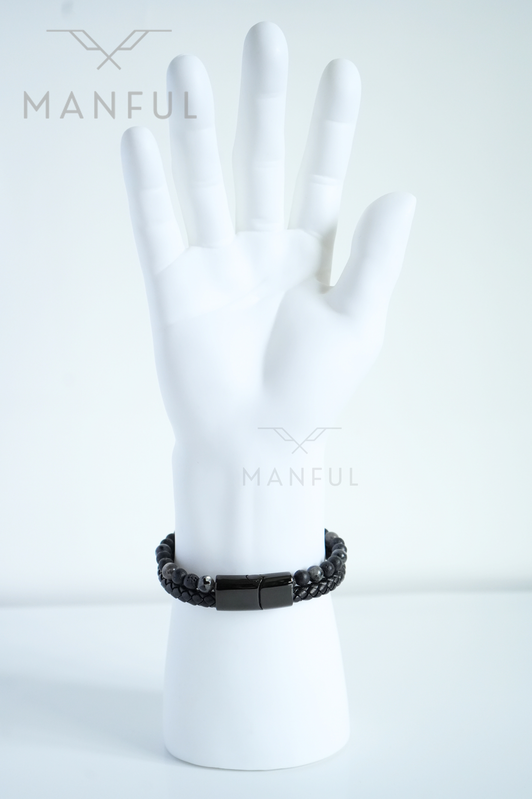 Charcoal Bead And Leather Bracelet, worn on a pale mannequin wrist, fingers spread