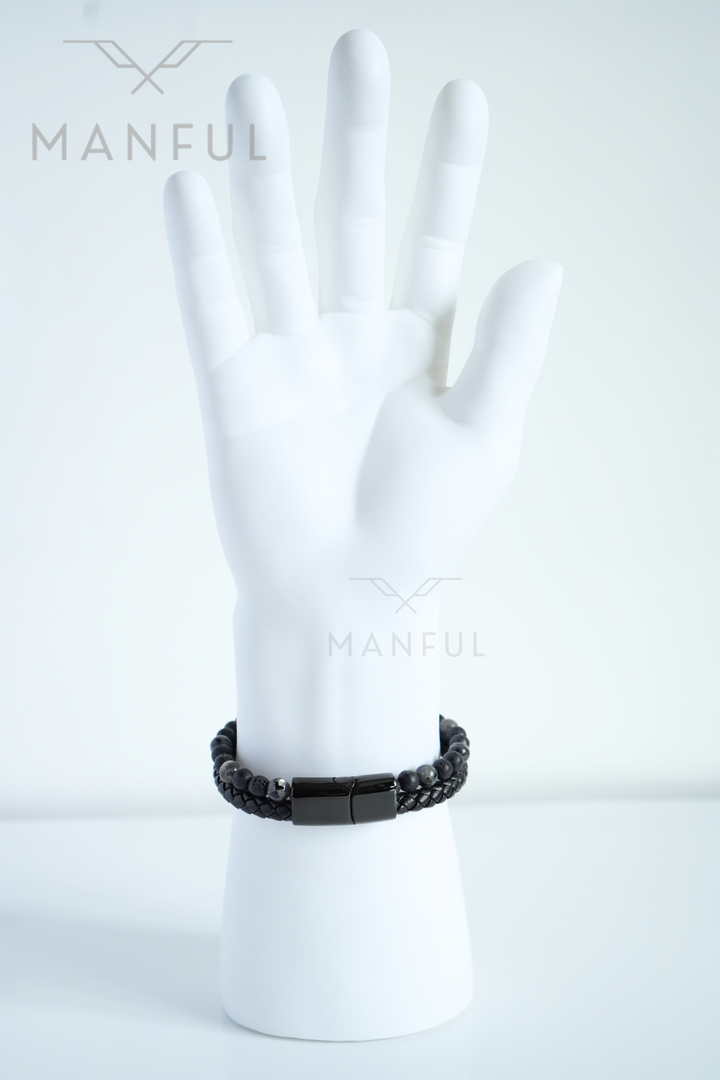 Charcoal Bead And Leather Bracelet, worn on a pale mannequin wrist, fingers spread