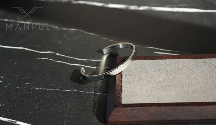 Adjustable Bangle Silver, close-up on the corner edge of the stone and wood stand