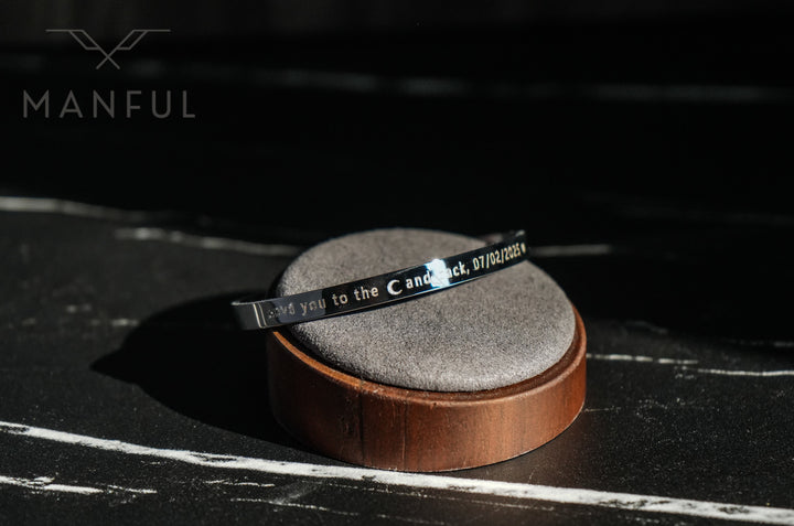 Adjustable Bangle Silver, engraved cuff on a round wood stand with a custom text engraving visible