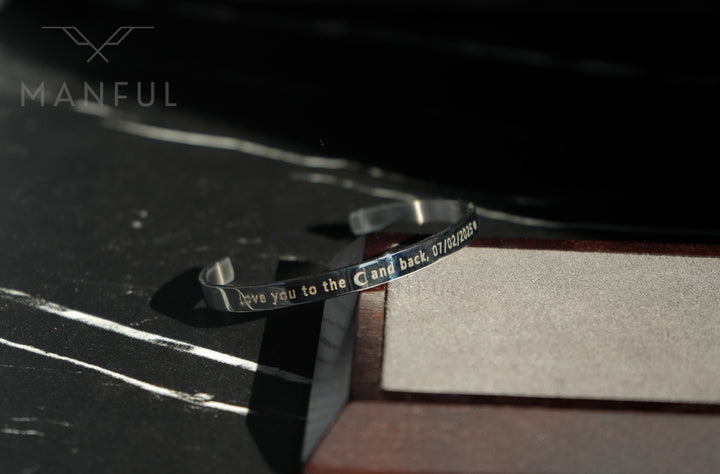 Adjustable Bangle Silver, close-up of the engraved band leaning against a dark backdrop