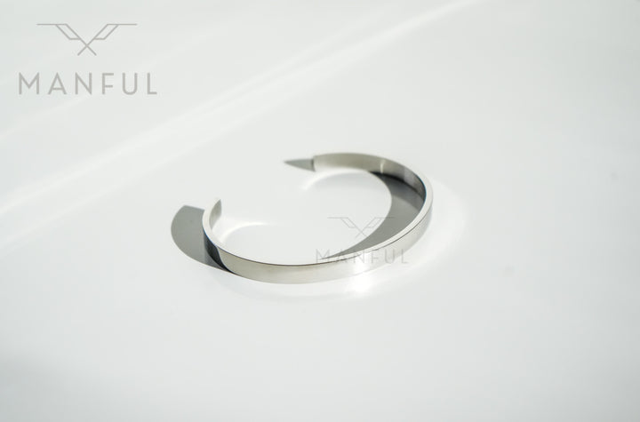 Adjustable Bangle Silver, isolated on a white background with the open ends angled upward