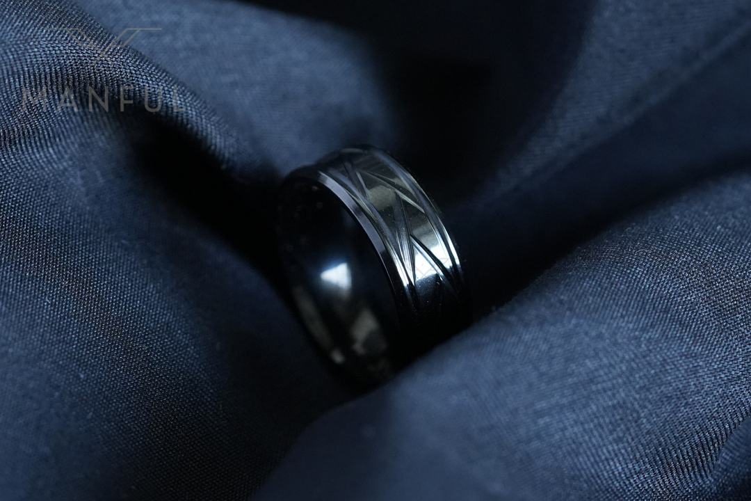 Crosscut Band Black, nestled in folds of navy blue satin fabric