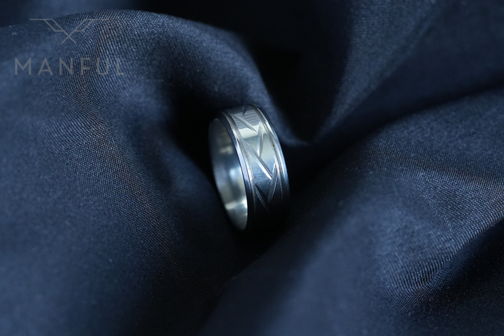 Crosscut Band Silver, nestled in the folds of dark navy satin fabric