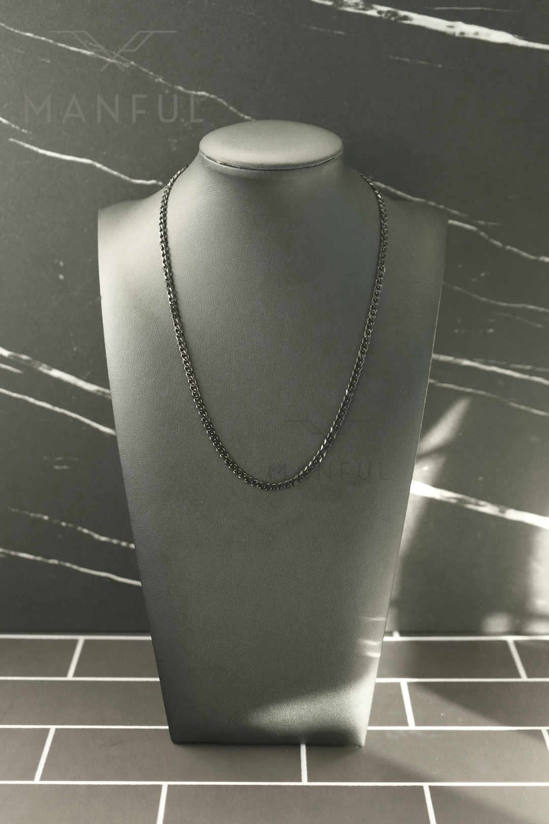 Cuban Chain 3mm Black, displayed on a grey bust against a marble-tiled backdrop