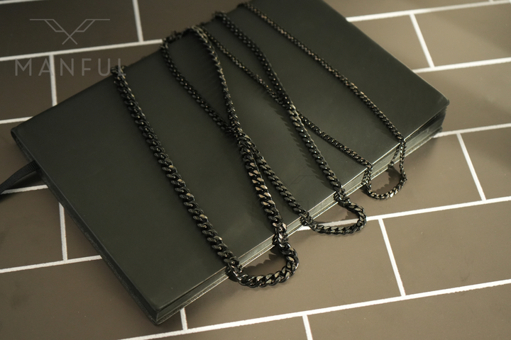 Cuban Chain 3mm Black, three widths draped unlabelled over a black book
