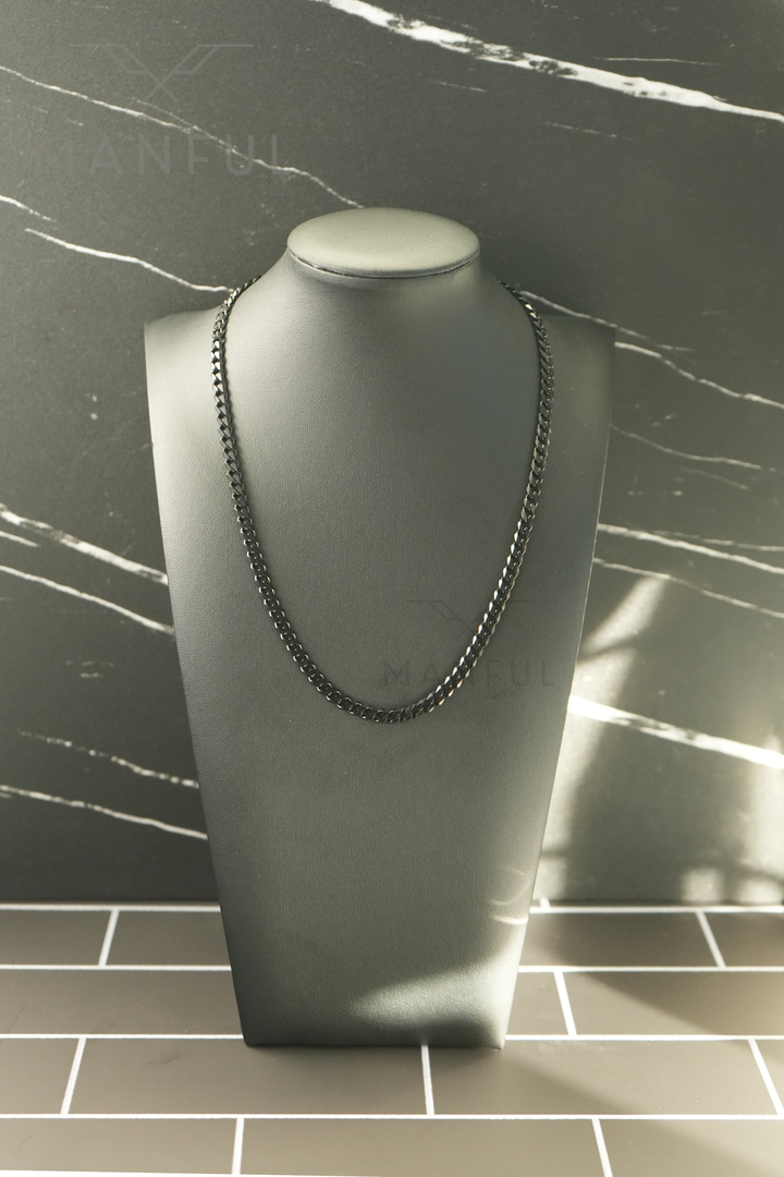 Cuban Chain 5mm Black, worn on a display bust against a marble backdrop with a tiled floor