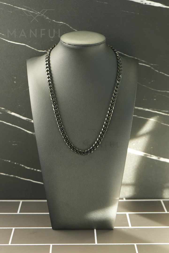 Cuban Chain 7mm Black, displayed on a dark bust with a marble tile background