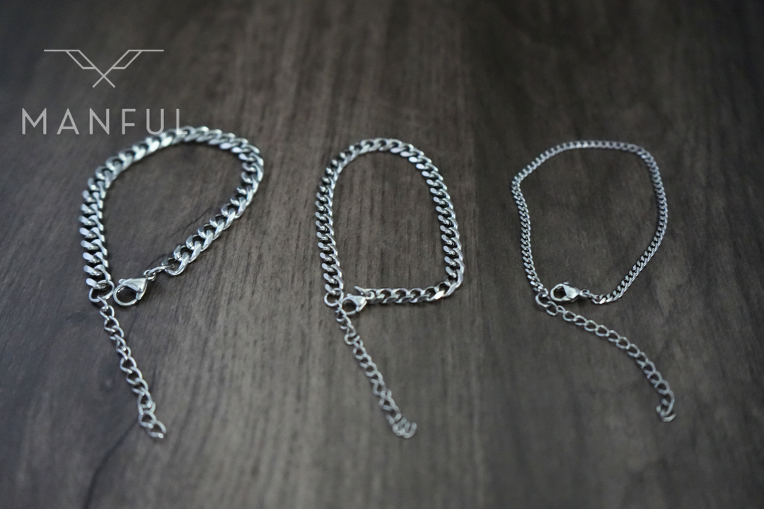 Cuban Chain Bracelet Silver, three widths laid flat side by side on a wood surface