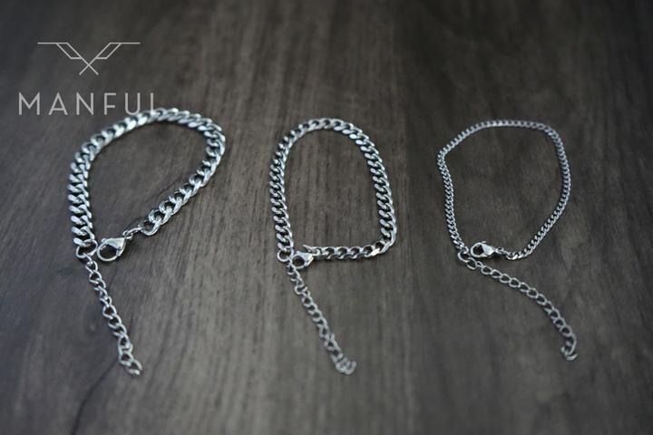 Cuban Chain Bracelet Silver, three widths laid flat side by side on a wood surface