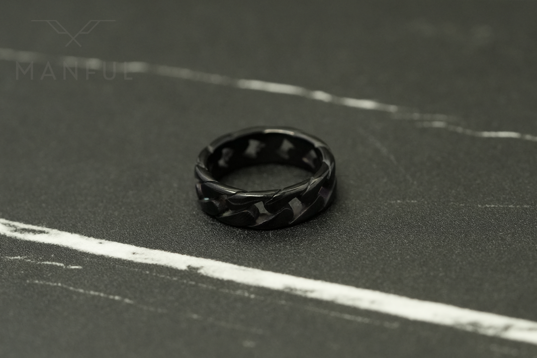 Cuban Chain Ring Black, standing upright on a dark marble surface