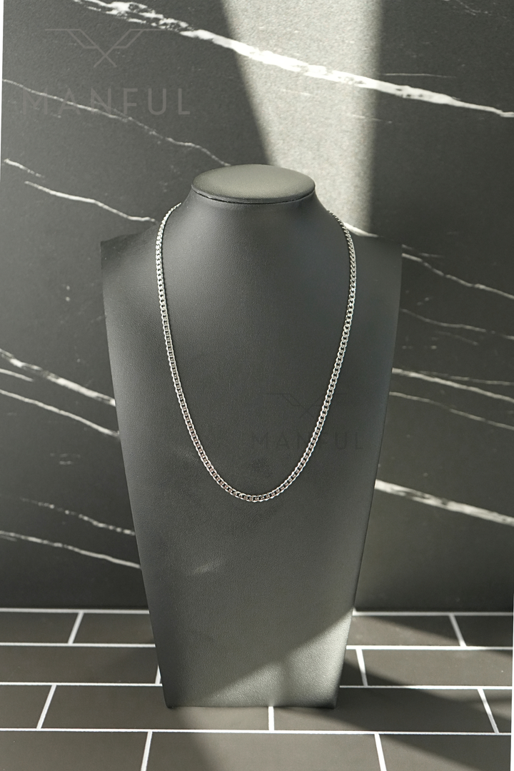 Cuban Chain 3mm Silver, hanging on a dark display bust against a marble backdrop